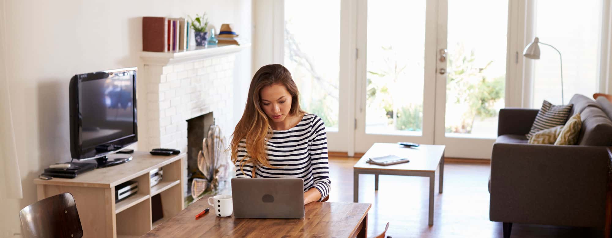 Woman working on her laptop in her living room.